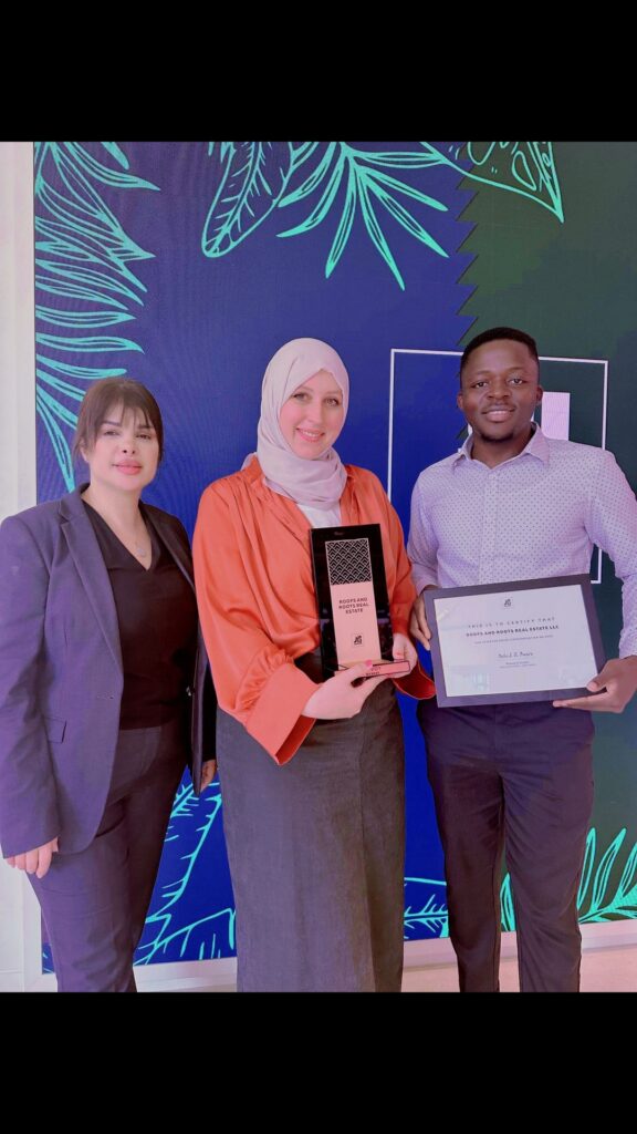 Mohammed Umar Zakaria holding Aldar's Envoy categorisation certificate awarded to Roofs and Roots Real Estate